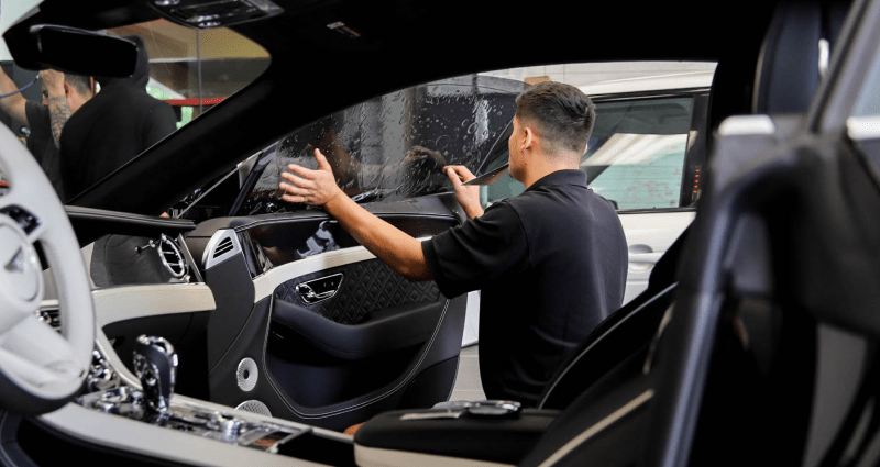 Man applying Car Window Tint to glass