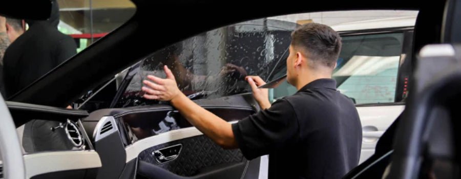 Man applying Car Window Tint to glass