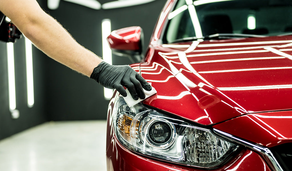 Gloved hand wiping Shiny red detailed car Our Services